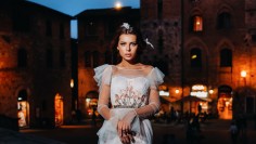 A bride in a white dress in the old town of San Gimignano.A girl walks around the city in Italy