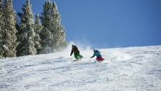 Couple Skiing On Snow Covered Mountain Against Sky