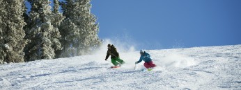Couple Skiing On Snow Covered Mountain Against Sky