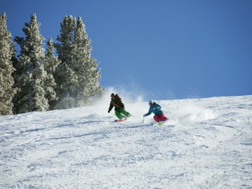 Couple Skiing On Snow Covered Mountain Against Sky
